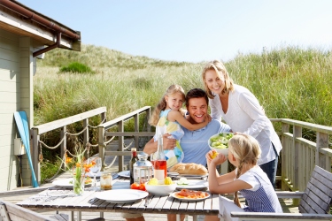 Family enjoying dinner by the beach after buying a vacation home