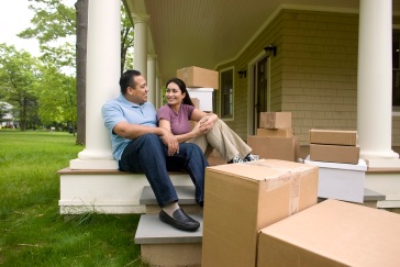 Couple with moving boxes discussing home buying tips